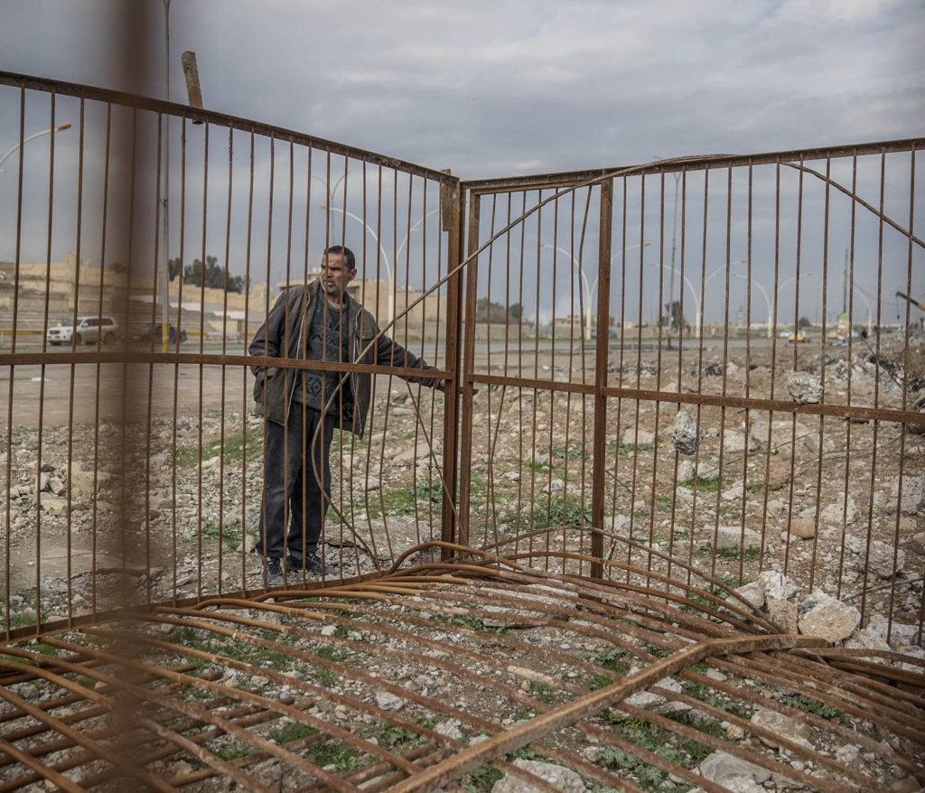 Adnan Tahar visar platser där is avrättade människor i östra Mosul. En stålbur står uppställd nedanför en stor läktare, där brukade IS bränna eller skjuta människor som de ansåg gjort något fel. Foto: Magnus Wennman